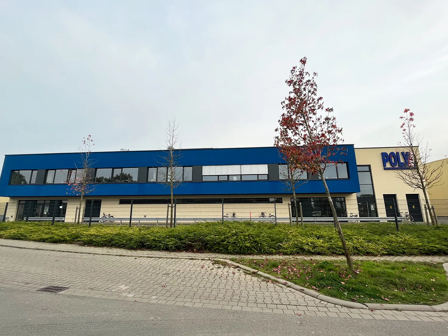 Außenansicht einer modernen Produktionshalle. An der Front befindet sich das Unternehmenslogo