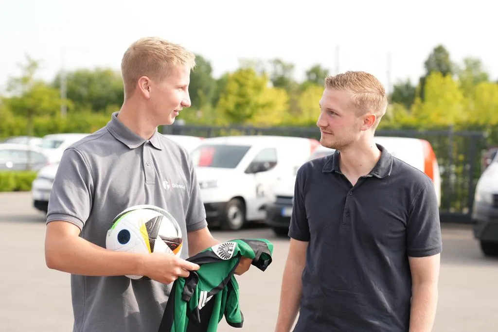 Dialog Azubi mit Fußball und Triko mit Fußbarrer
