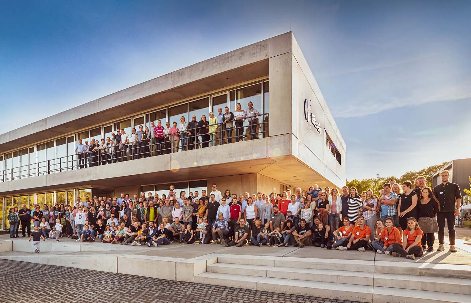 Gruppenfoto der Mitarbeitenden vor dem Firmengebäude