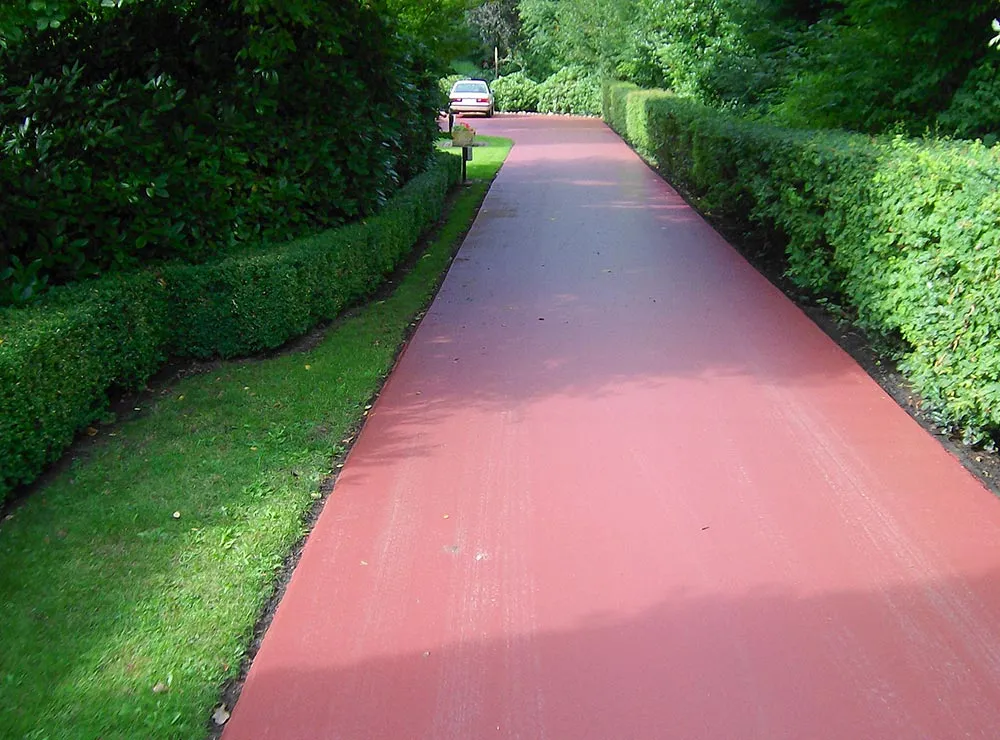 Roter Weg durch eine grüne Park- und Gartenanlage