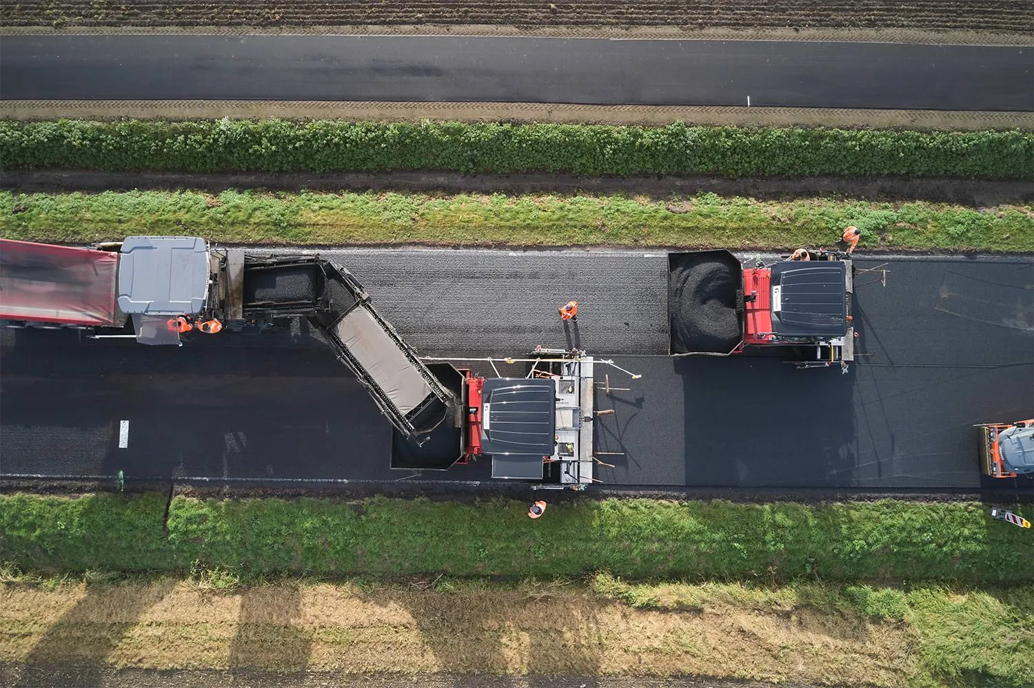 Asphaltarbeiten mit Straßenfertiger und Walzen aus der Luft