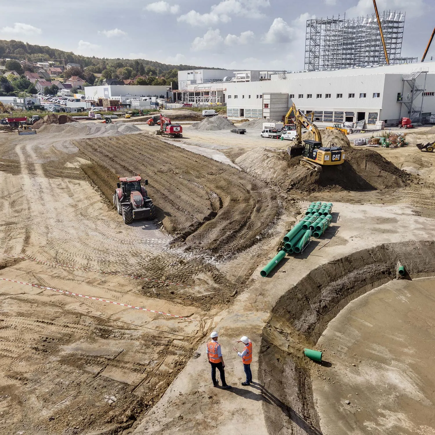 Luftaufnahme einer Großbaustelle mit Erdarbeiten und Rohrleitungen