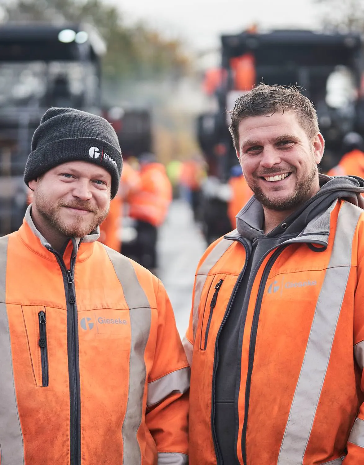Zwei Mitarbeitende in Warnkleidung auf einer Straßenbaustelle