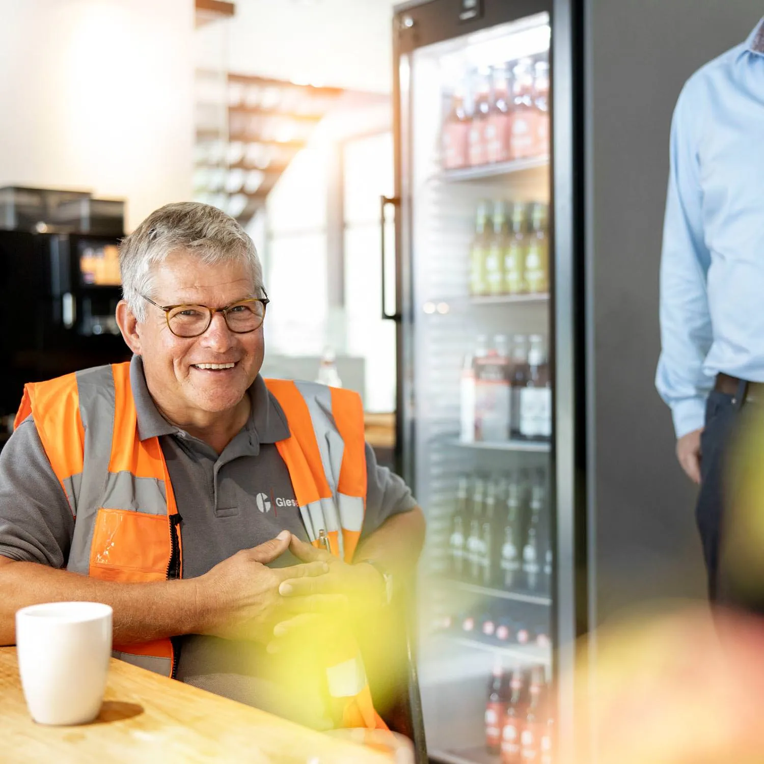 Mitarbeiter in Warnweste bei einer Pause im Aufenthaltsbereich