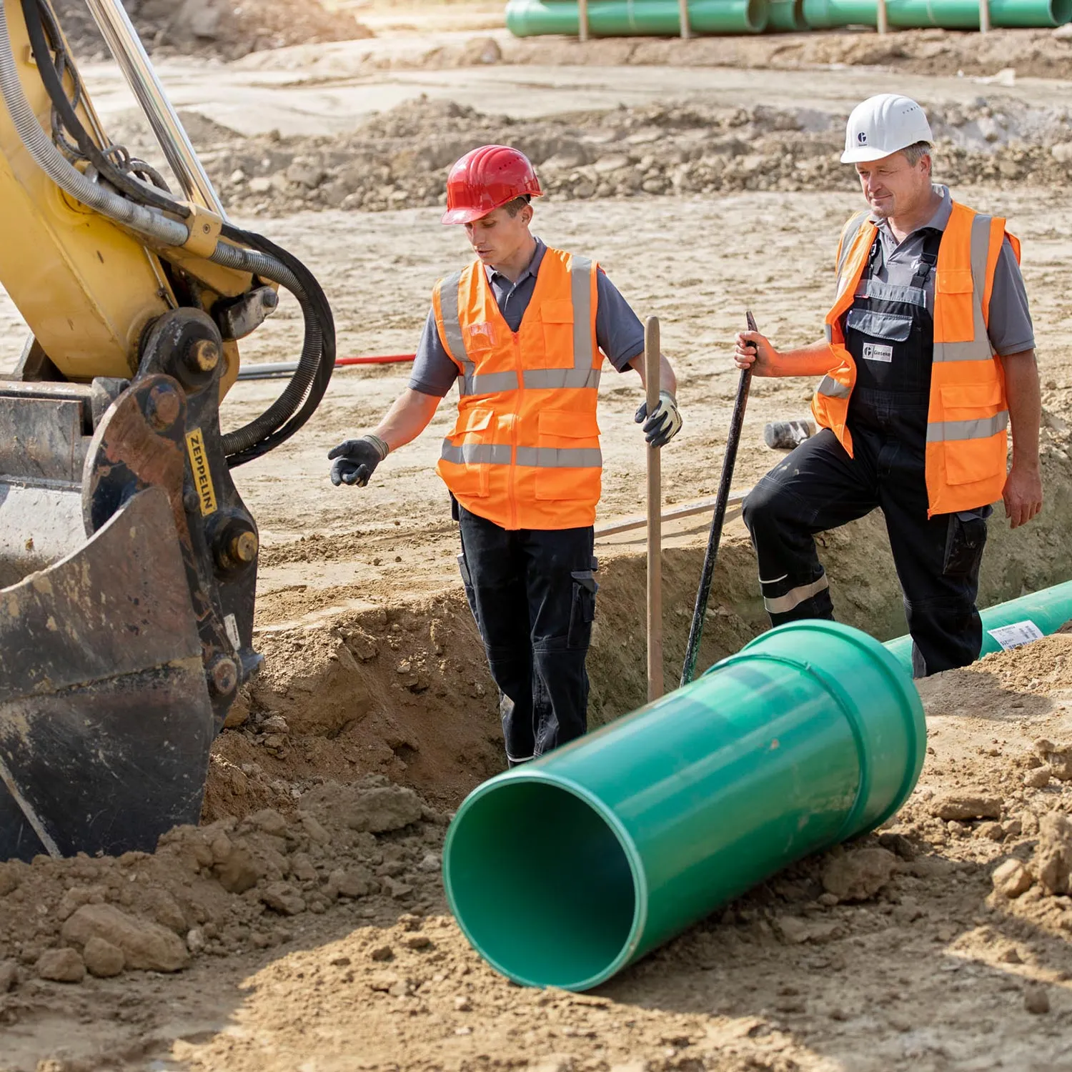 Kanalbau-Team mit Vermessungsgerät auf der Baustelle