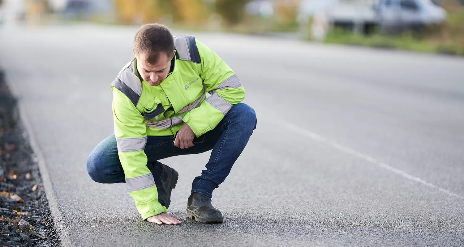 Bauleiter prüft die Oberfläche einer neu asphaltierten Straße