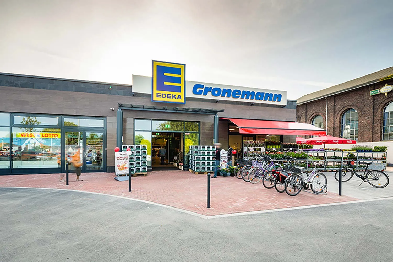 Eingangsbereich des EDEKA-Markts Gronemann mit Fahrrädern, Vordach und Verkaufsfassade.
