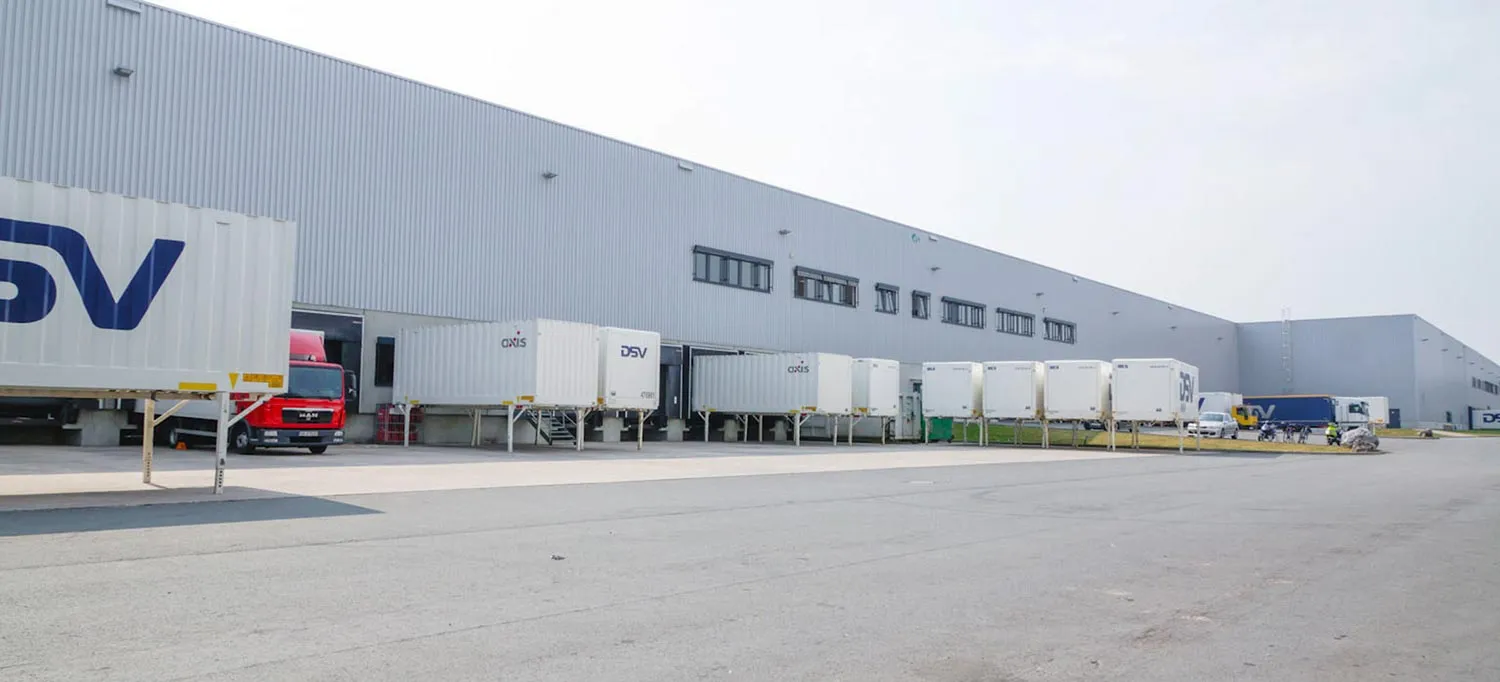 Logistikhalle mit angedockten Wechselbrücken an mehreren Verladetoren und befestigter Vorfläche.