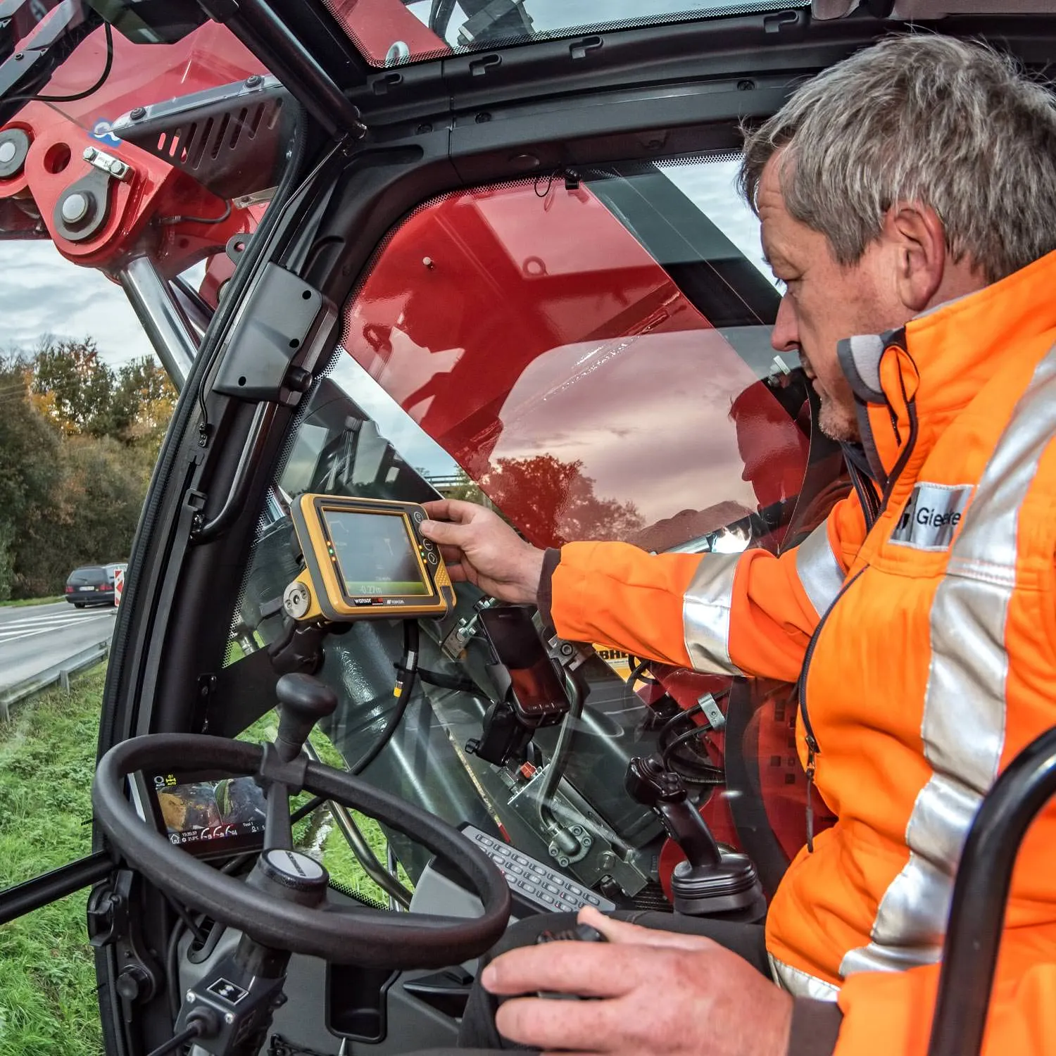 Mitarbeiter in einer Baumaschine bei der Bedienung eines Steuerdisplays