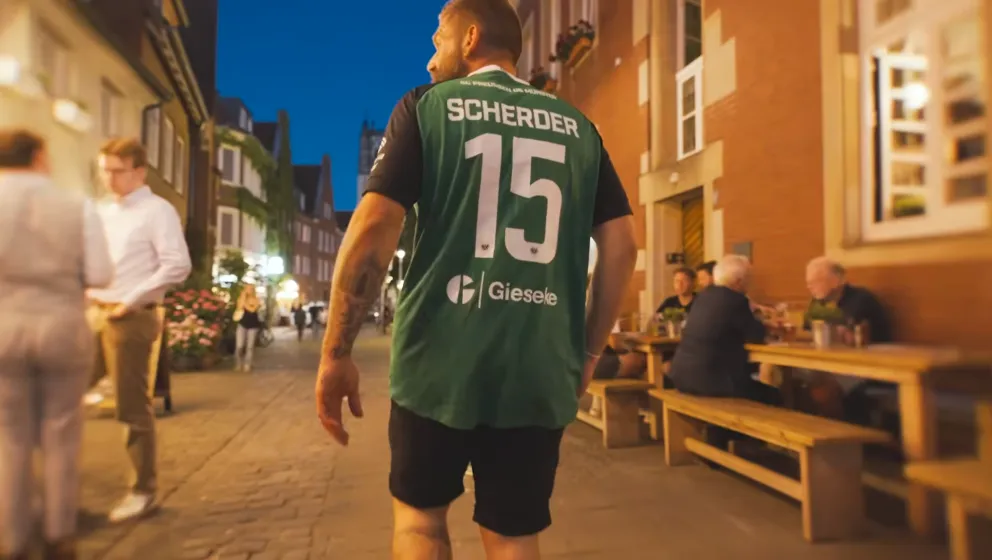 Mann trägt das Trikot und läuft durch die Münsteraner Altstadt