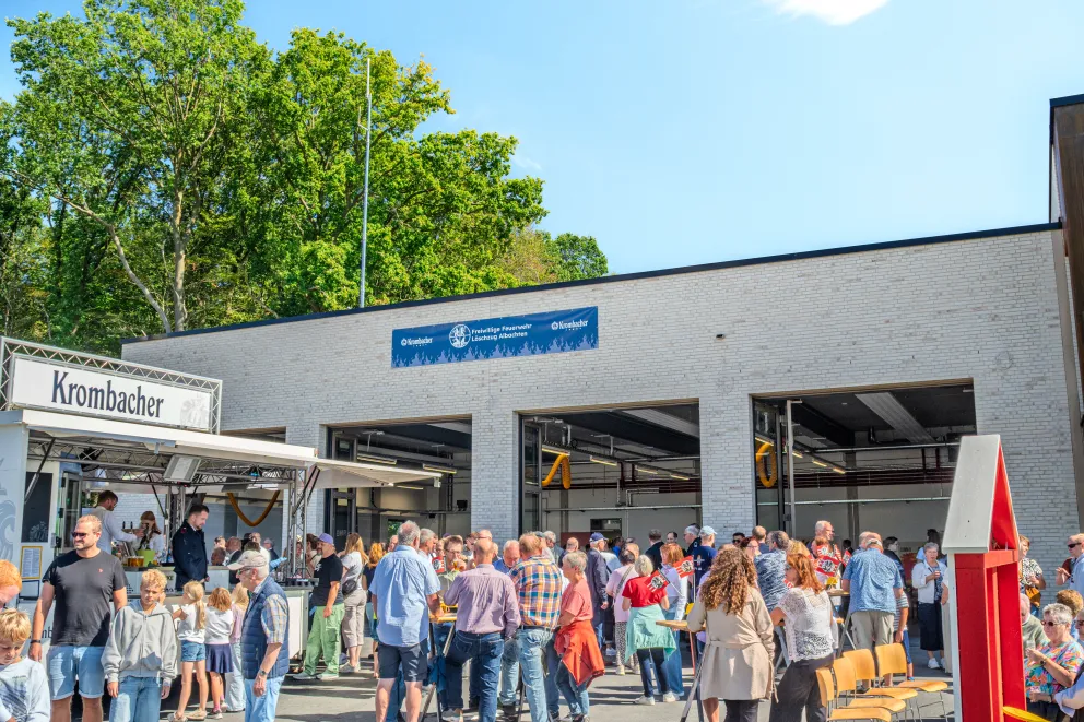Viele Besucherinnen und Besucher vor einem modernen Gebäude bei einer Veranstaltung im Außenbereich.