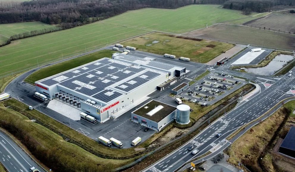 Luftaufnahme eines Logistikzentrums mit Logistikhalle und Verkehrsflächen