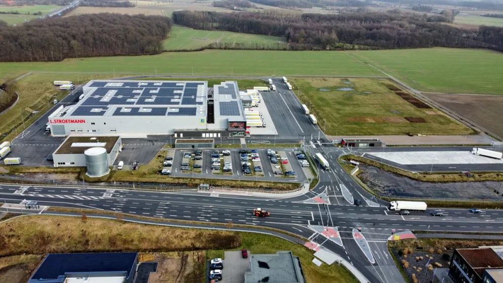 Luftaufnahme eines großflächigen Logistikzentrums an einer Hauptstraße