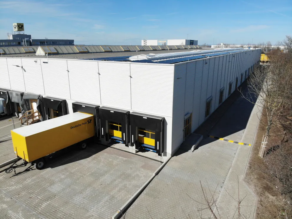 Andienungsseite der Hallenerweiterung am Briefzentrum mit Verladetoren und DHL-Fahrzeug.  Bild 2 rechts