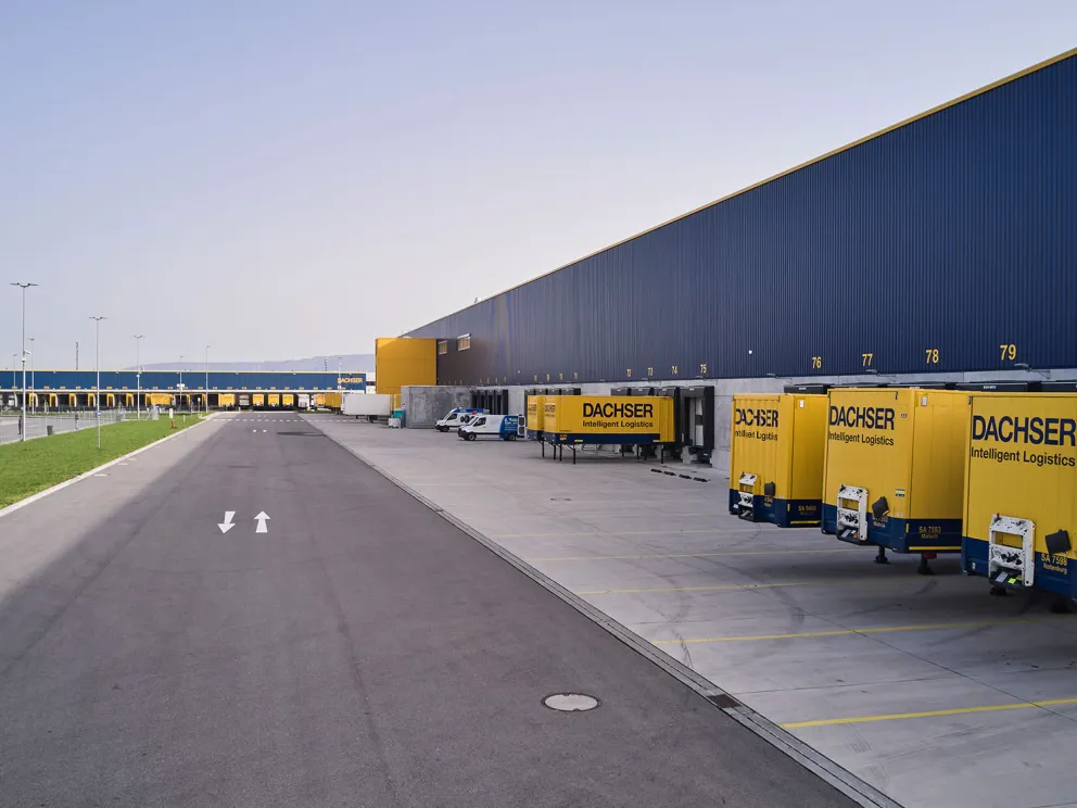 Verladebereich eines Dachser-Logistikzentrums mit Hallenfront und abgestellten Wechselbrücken.